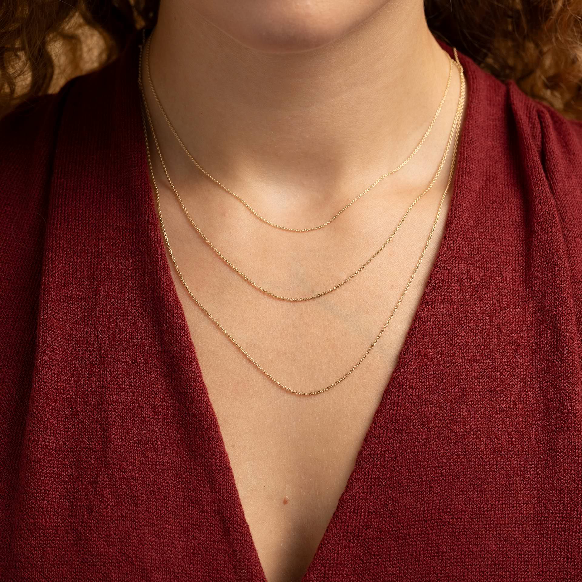 Ein Schmuckstueck mit Bedeutung: Goldkette mit Symbolanhaenger als persoenliches Geschenk fuer Herzensmenschen.